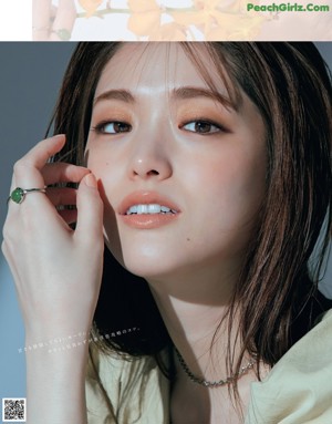 A woman with long brown hair is posing for a magazine.