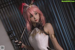 A woman with pink hair wearing a bunny ears headband.