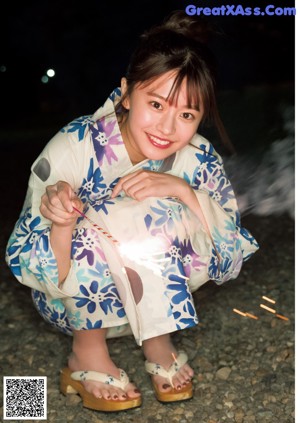 A woman in a pink shirt is posing for a magazine.