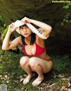 A young woman wearing a straw hat in the grass.