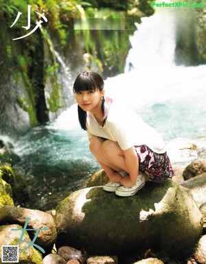 A young woman wearing a straw hat in the grass.