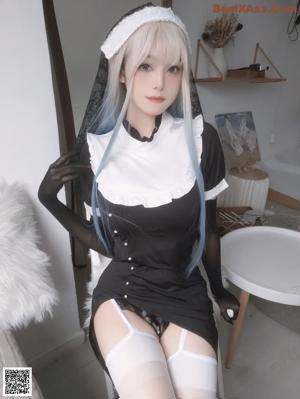 A woman in a black and white outfit is posing for a picture.