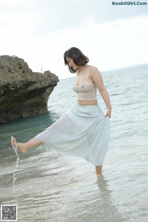 A woman in a white bra holding a bone in her hand.