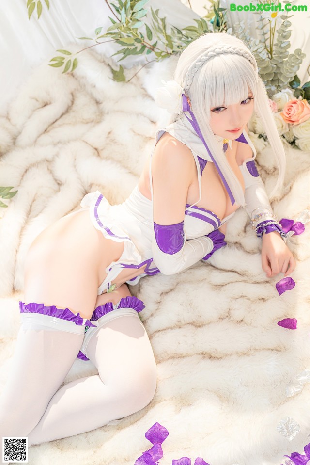 A woman in a white and purple outfit laying on a bed.