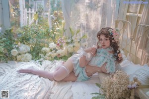 A woman in a blue and white lingerie posing in front of a window.