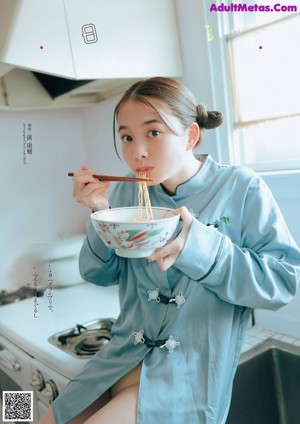 A woman wearing a blue shirt with panda embroidery on it.