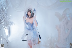 A woman laying on top of a bed in a blue dress.