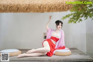 A woman in a pink kimono laying on the floor.