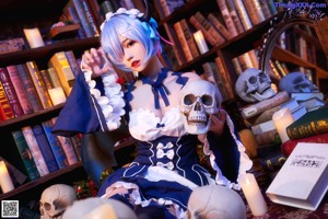 A woman sitting on a stool in front of a book shelf.