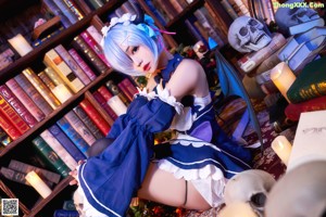 A woman in a blue and white dress sitting on a rug.