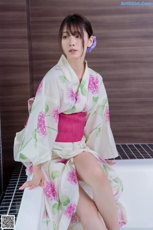 A woman sitting in a bathtub filled with water and flowers.