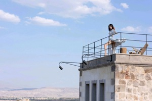 A woman in a short skirt and high heels is standing on some stairs.