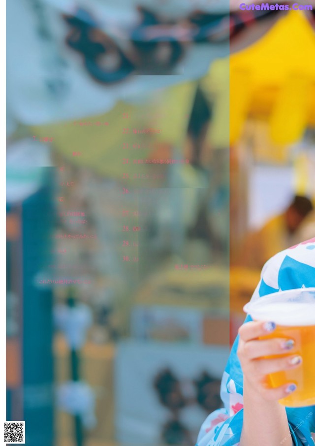 A woman holding a cup of orange juice in her hand.
