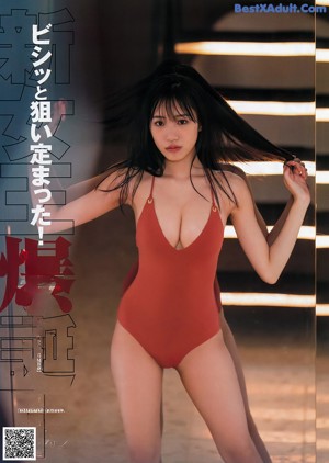 A woman in a red bikini sitting on a bed.