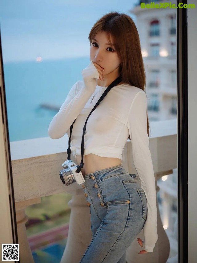 A woman in a white shirt and jeans posing for a picture.