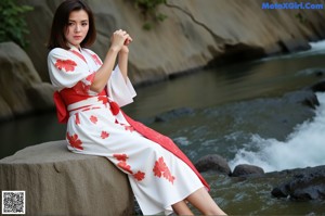 A woman in a colorful dress posing in front of a bamboo forest.