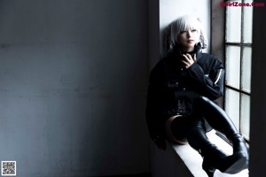 A woman in a black and white outfit laying on a wooden floor.