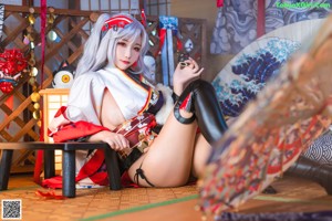 A woman in a kimono sitting on a bed.