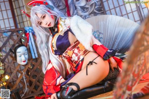 A woman in a kimono sitting on the floor.