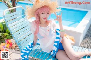 A woman in a bikini posing by a pool with an umbrella.