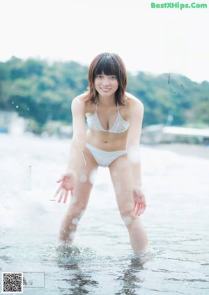 A woman in a blue bikini posing for a picture.